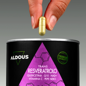 Mano che tiene una capsula sopra il barattolo di Resveratrolo Aldous con quer...